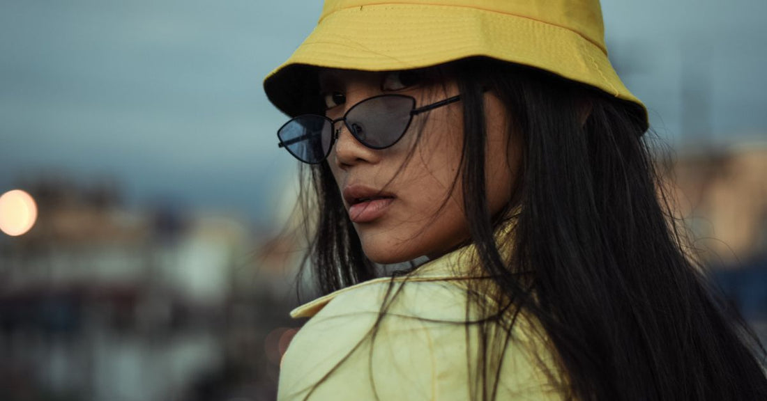Femme portant un bob jaune et des lunettes de soleil en été