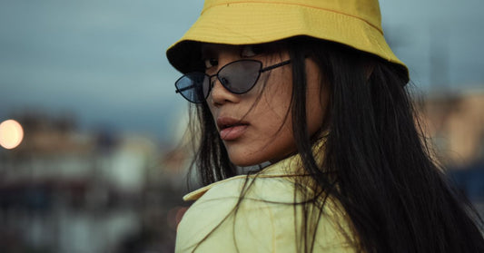 Femme portant un bob jaune et des lunettes de soleil en été