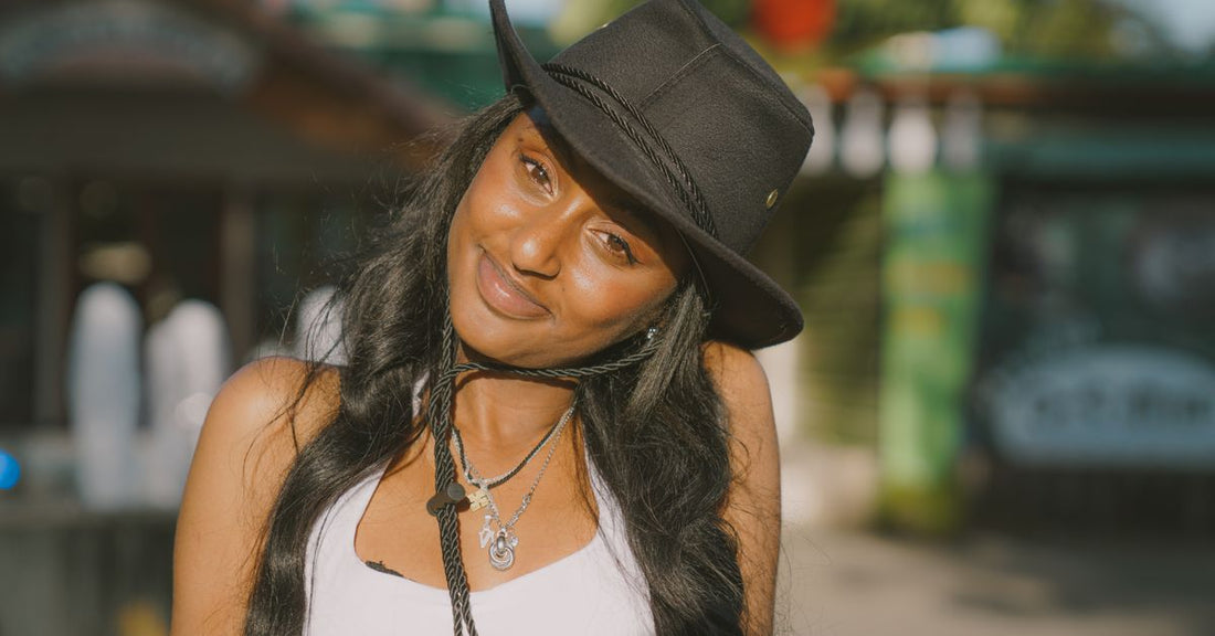 Femme souriante portant un chapeau cowboy au soleil en été