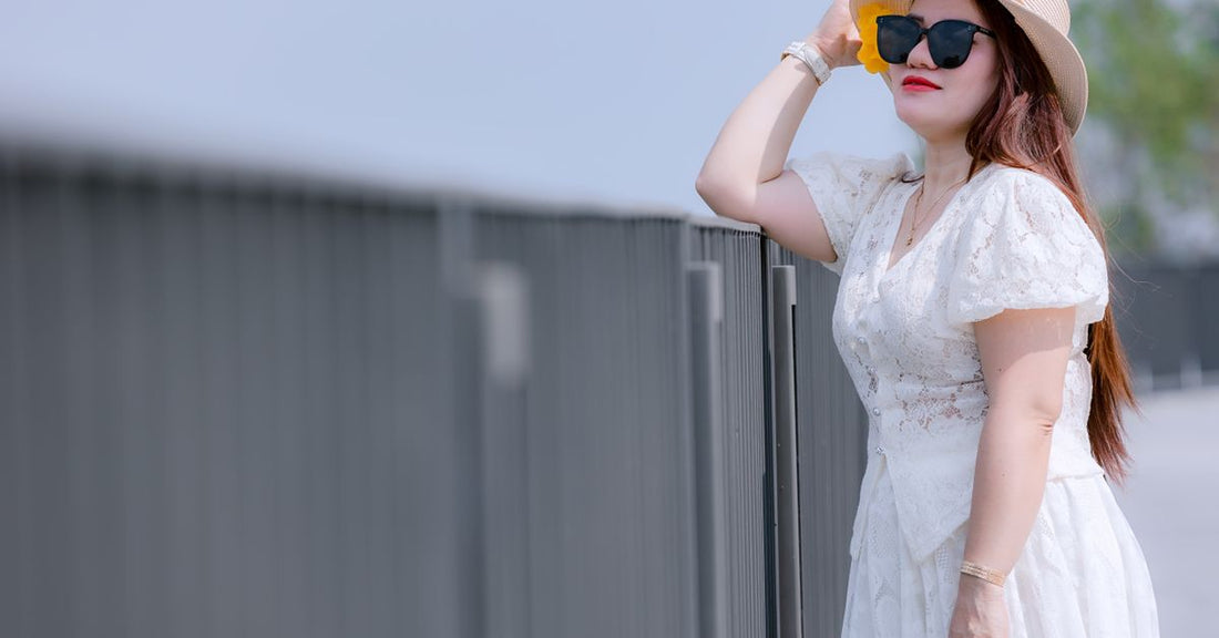 Femme en robe blanche portant un chapeau de soleil en extérieur