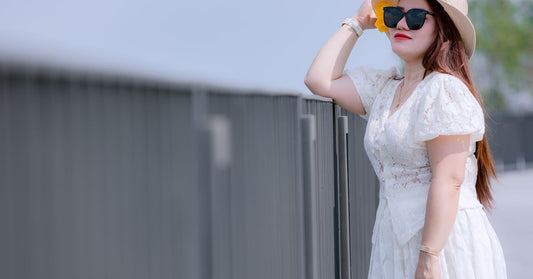 Femme en robe blanche portant un chapeau de soleil en extérieur