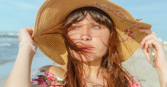 Femme portant un chapeau de plage en paille au bord de la mer en été
